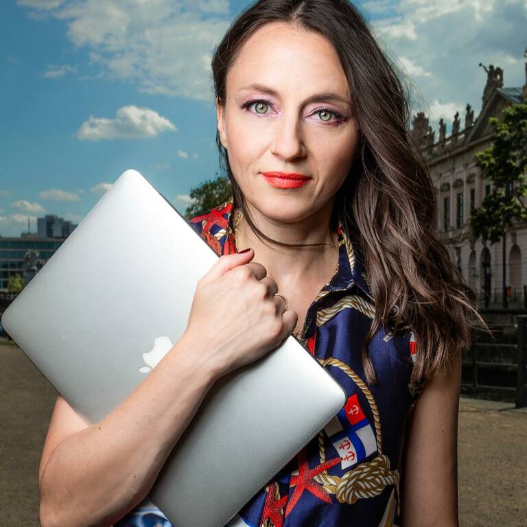 Woman holds a Macbook in her arm