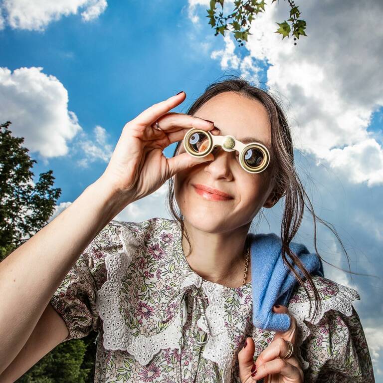 Woman looks into the distance with binoculars