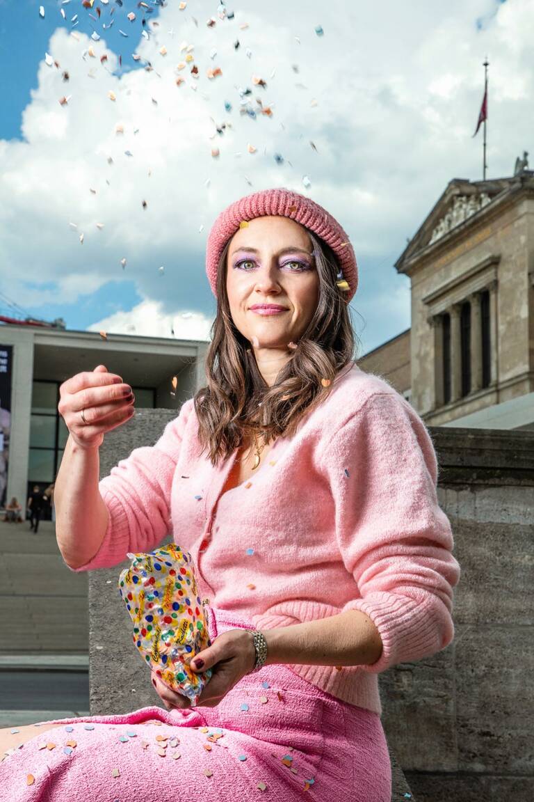 Frau wirft Konfetti in die Luft