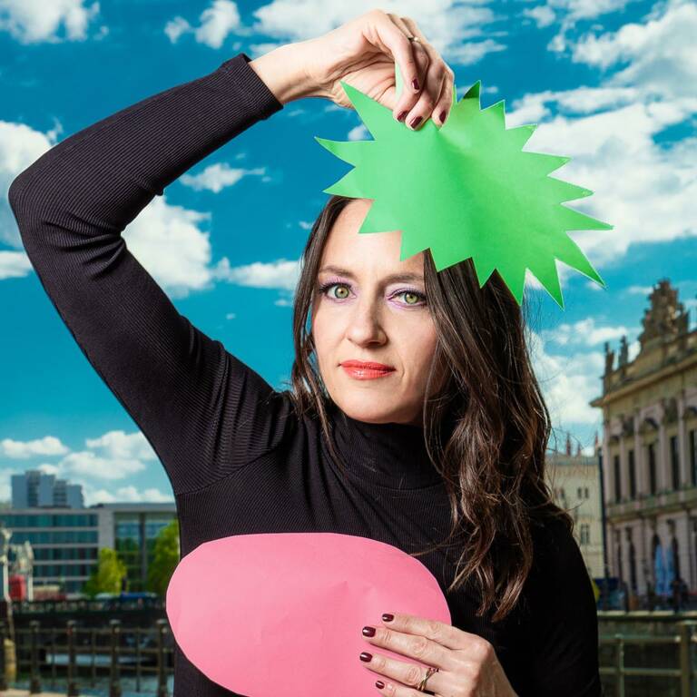 Women holds paper speech bubbles in the air