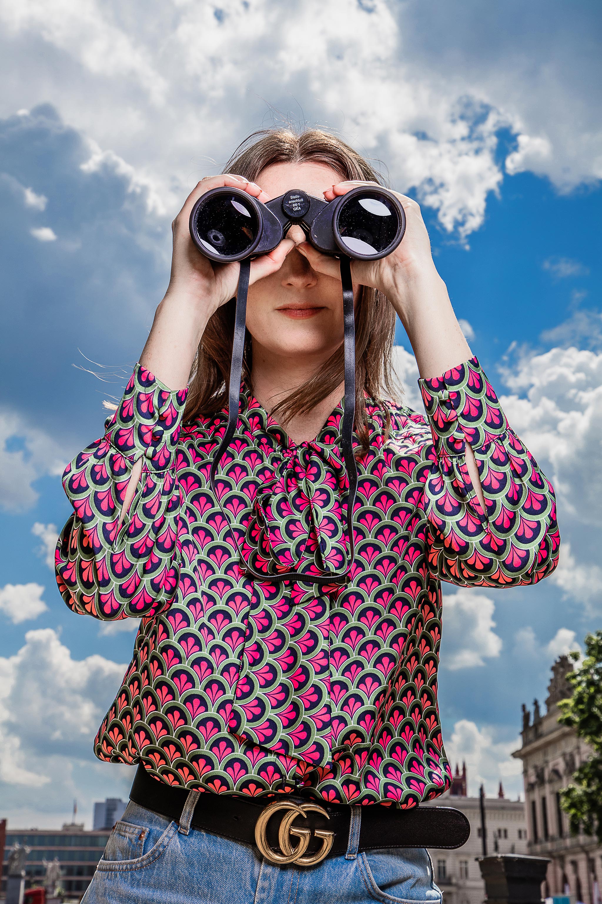 Frau schaut mit Fernglas in die Ferne