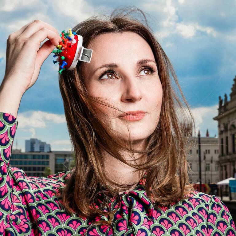 Woman holds a pin cushion to her head