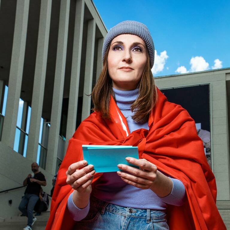 Woman stands on a staircase holding notecards