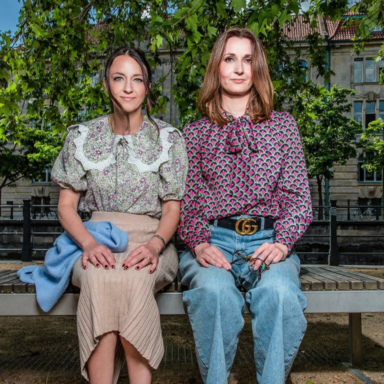 Two women sitting together on a bench